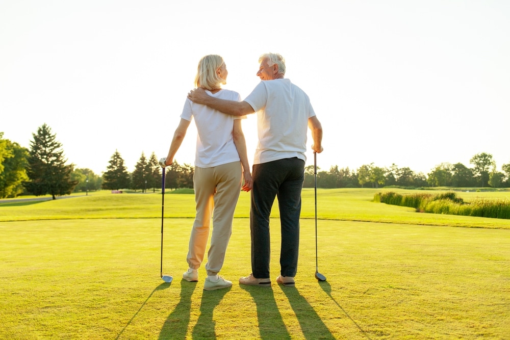 Elderly,senior,couple,in,uniform,playing,golf,on,golf,course